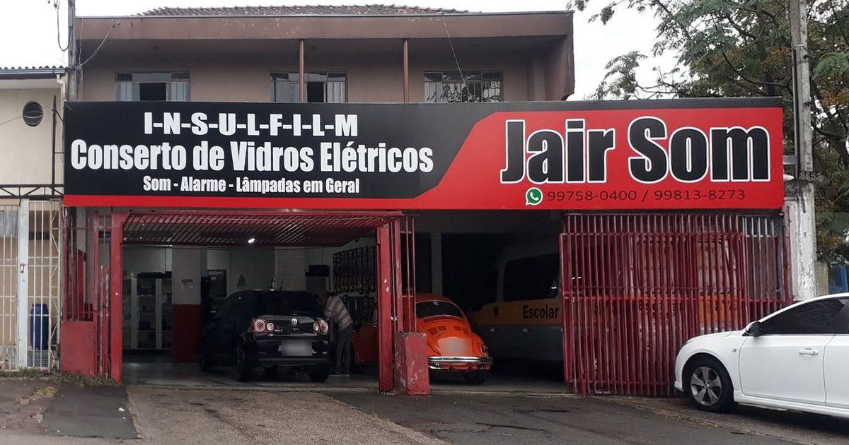 Fachada da Jair Som na Rua Cid Marcondes de Albuquerque, com a placa da loja e carros na entrada