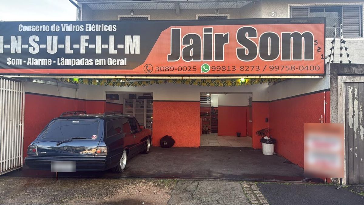 Fachada da Jair Som na Rua Barão de Santo Ângelo, com a placa da loja e a entrada da oficina